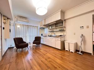 a kitchen with two chairs and a table in a room at 北浜 港近くの個室ステイ in Takamatsu