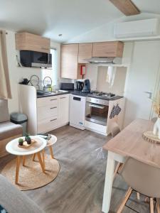 a kitchen and living room with a table and a couch at La plage in Canet-en-Roussillon