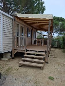 a cabin with awning and stairs in front of it at La plage in Canet-en-Roussillon