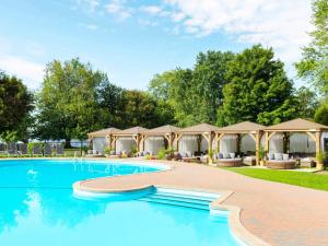 a swimming pool with a group of tents at Fairmont Le Chateau Montebello in Montebello