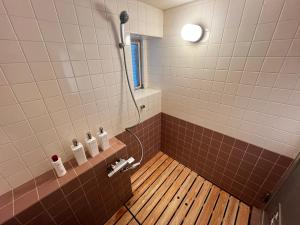 a bathroom with a shower with a wooden floor at 北浜 港近くの個室ステイ in Takamatsu