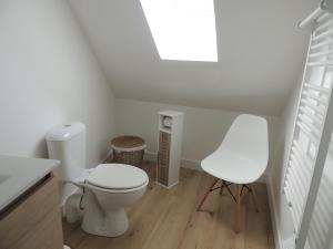 a white bathroom with a toilet and a chair at Chambre d'hôte Monthorin in Vernie +24 photos
