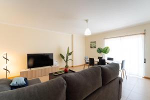 a living room with a couch and a flat screen tv at T2 Arte Xávega in Nazaré