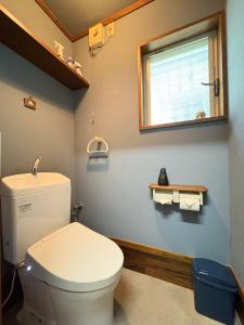 a bathroom with a white toilet and a window at Dons House in Fukuoka