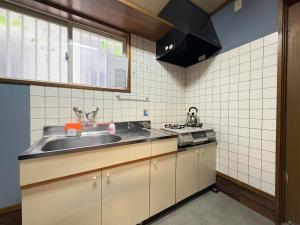 a small kitchen with a sink and a stove at Dons House in Fukuoka