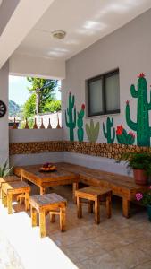 a patio with wooden benches and cacti on the wall at Hanna's Hostel in Berat