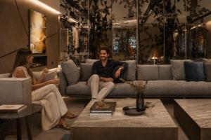 a man and woman sitting on a couch in a living room at VP Plaza España Design in Madrid +46 photos
