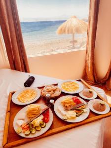 a tray with plates of food on a table near the beach at Nour camp in Nuweiba