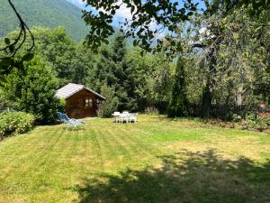 a yard with a table and chairs and a cabin at Appartement Oz en Oisans in Oz