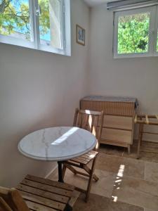 a table and a chair in a room with a window at l'Annexe, logement confortable avec piscine in Mazan
