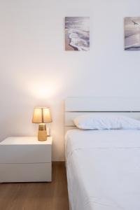 a bedroom with two beds and a lamp on a night stand at Due passi dal mare - Residence Sirena in Punta Marina