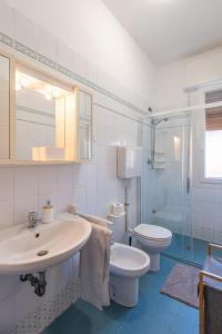 a white bathroom with a sink and a toilet at Due passi dal mare - Residence Sirena in Punta Marina +13 photos