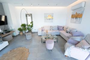 a living room with a couch and a table at Villa Cycladic View Syros in Azolimnos Syros