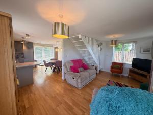 a living room with a staircase and a couch at Peaceful Red Deer Cosy Apt in Letterfrack near The Connemara National Park in Letterfrack