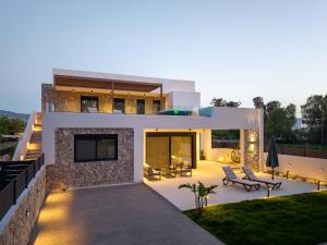 a modern house with a patio and a lawn at Besa Luxury Villas in Kos