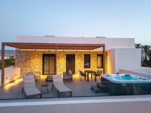 a patio with a table and chairs and a hot tub at Besa Luxury Villas in Kos