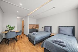 two beds in a room with a table and a desk at Central Platinum Apartments 12 in Rybnik