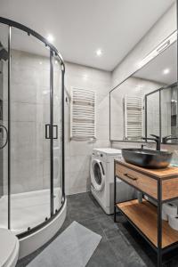 a bathroom with a sink and a washing machine at Central Platinum Apartments 12 in Rybnik
