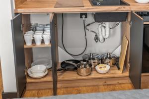 a kitchen shelf with dishes and utensils on it at Central Platinum Apartments 12 in Rybnik