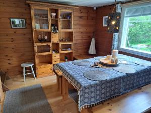 a dining room with a table in a cabin at Peaceful riverside cottage with sauna in Myllykylä