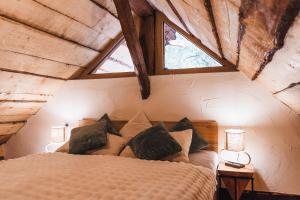 a bedroom with a bed with two windows at The Nook - Sauna, Pool, Ice Bath in Celje