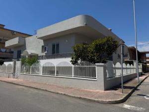 a white fence in front of a house at THE PORT Guest Rooms in San Ferdinando