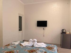 a room with a bed with towels and a tv at Oasis in Akhaltsikhe