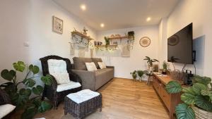 a living room with a couch and a tv at Tanny Boho Housy na pešej zóne in Piešťany
