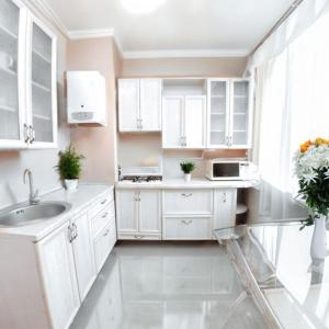 a white kitchen with white cabinets and a sink at Кардиоцентр in Dnipro