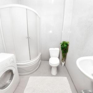 a white bathroom with a toilet and a sink at Кардиоцентр in Dnipro