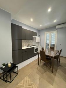 a kitchen with a table and a dining room at THE PORT Guest Rooms in San Ferdinando