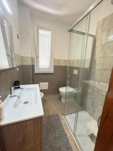 a bathroom with a sink and a shower and a toilet at THE PORT Guest Rooms in San Ferdinando