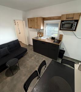 a small living room with a couch and a kitchen at Apartment Zart 2 in Dekani