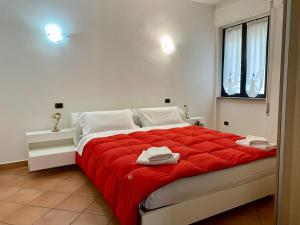 a bedroom with a large bed with red blanket at Nuvola House in Mandello del Lario
