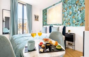 a hotel room with a bed and a table with food and drinks at Hôtel Mijo's in Fontenay-sous-Bois