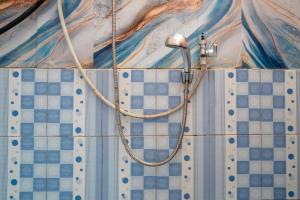 a shower in a bathroom with blue and white tiles at TB Villa Resort By ARBA in Palayangan