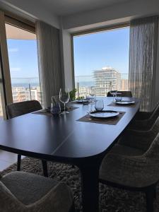 a dining room table with chairs and a large window at Spacious and modern apartment with open sea view in Ostend