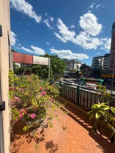 a balcony with pink flowers on a city street at An Phú Nguyễn Hoàng Hotel in Hanoi