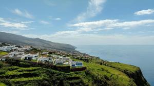 a group of houses on a hill next to the ocean at Villa Serenity by Rentallido in Prazeres
