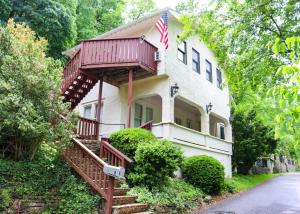 a house with a balcony with an american flag on it at Over the Rainbow Suites in Eureka Springs