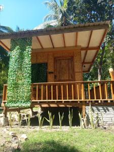 a house with a deck and a tree at A2 Coconut in Pulau Sarang