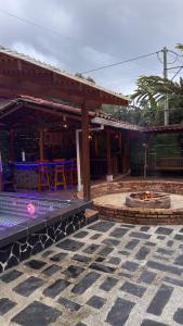 a house with a fire pit in a courtyard at Hostal la Divisa Salento in Arrayanal