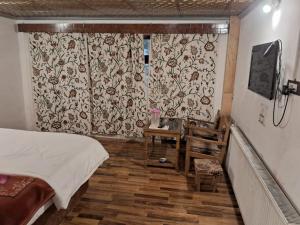 a bedroom with a bed and a window with a curtain at Hotel king palace in Pahalgām