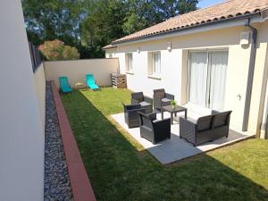 a patio with chairs and a table in a yard at Évasion à Bruguières in Bruguières