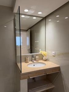a bathroom with a sink and a large mirror at Small home Pyrgos in Panormos +13 photos