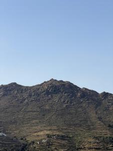 a mountain with a blue sky in the background at Small home Pyrgos in Panormos