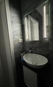 a bathroom with a white sink and a mirror at Apartment Zart 2 in Dekani +6 photos