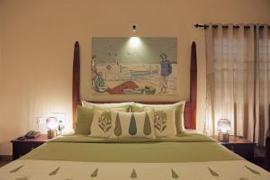 a bedroom with a large bed and a painting on the wall at Dutch Manor Boutique Hotel in Cochin +22 photos