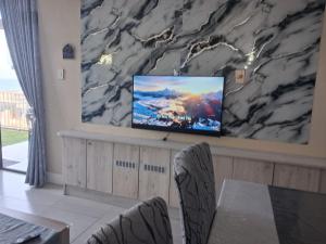 a living room with a tv on a wall at Ocean Breeze 12 Boulder Bay in Ballito