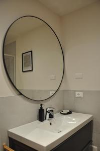 a bathroom with a sink and a large mirror at L'Oasi Amena - Loft in Ameno +12 photos